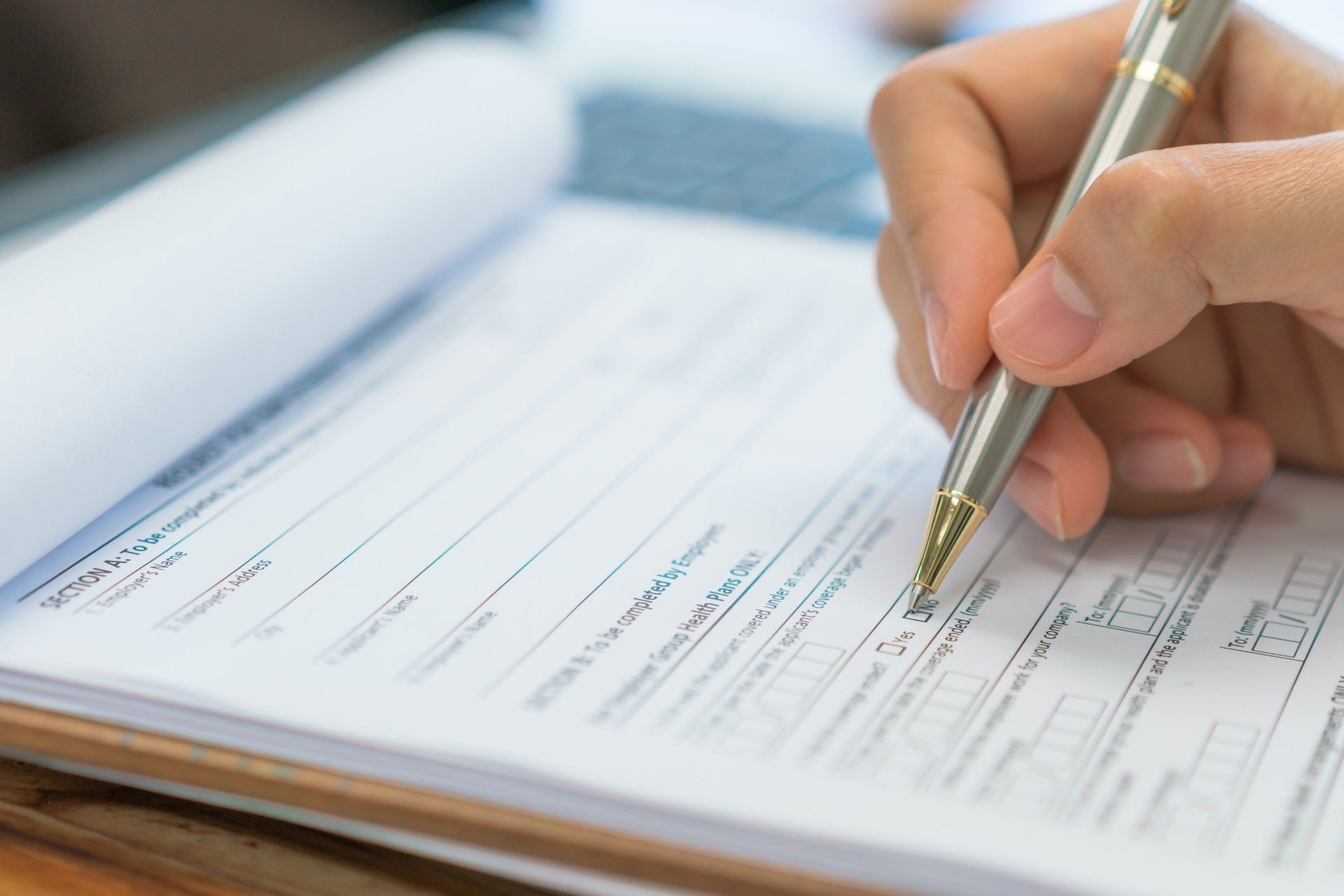 A person is writing on a piece of paper with a pen.