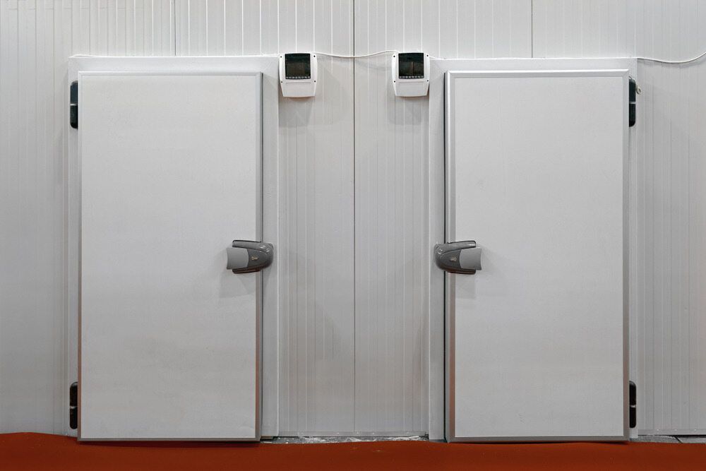 A Couple of White Doors in a Room With a Red Floor — Noosa Refrigeration & Air-conditioning in Cooroy, QLD