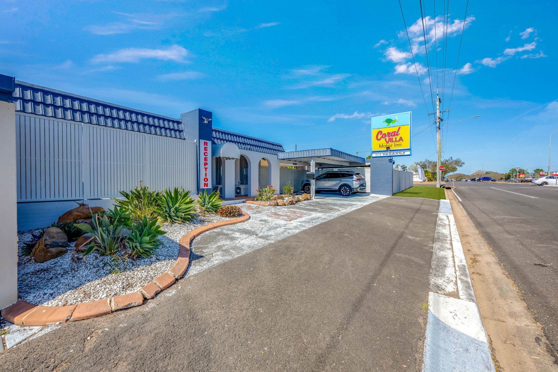 Coral Villa sign beside a tan building under a clear blue sky