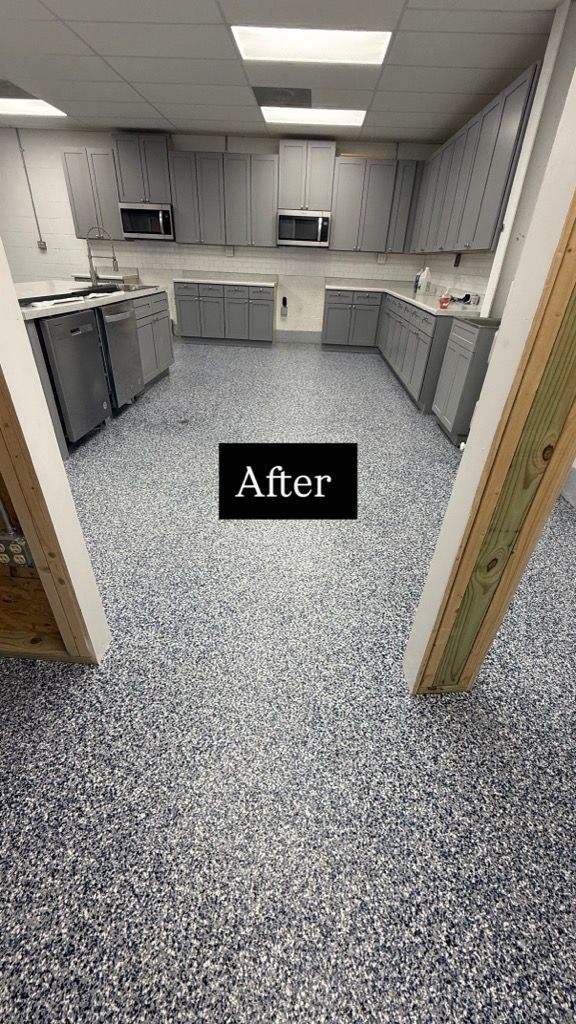 Small gray kitchen with white cabinets, speckled flooring, and an 