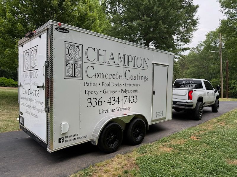 White utility trailer for “Chameleon Concrete Coatings” parked on a grassy roadside, hitched to a pickup truck.