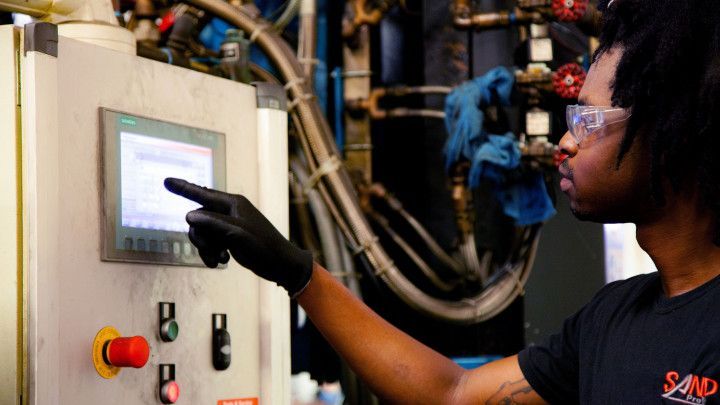 Black man operating a machine