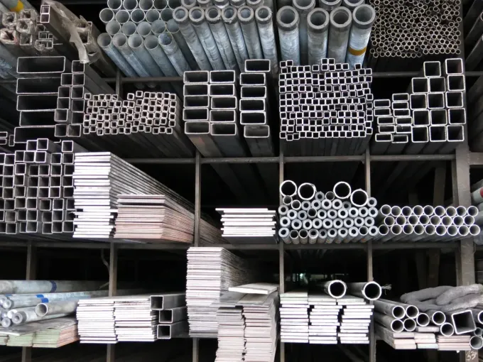 Shelves stacked with assorted metal pipes and tubing in a storage yard