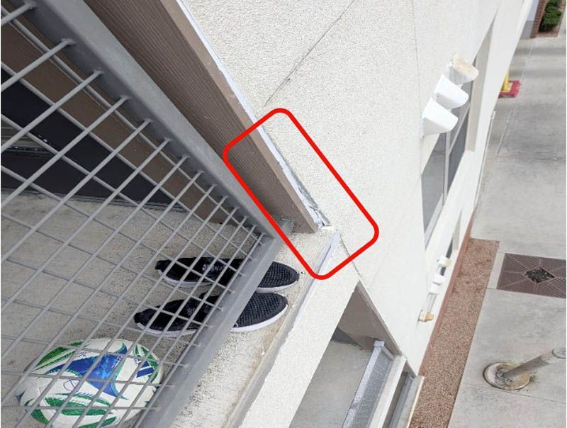 Failed sealant is observed above the balcony with a likely water intrusion.