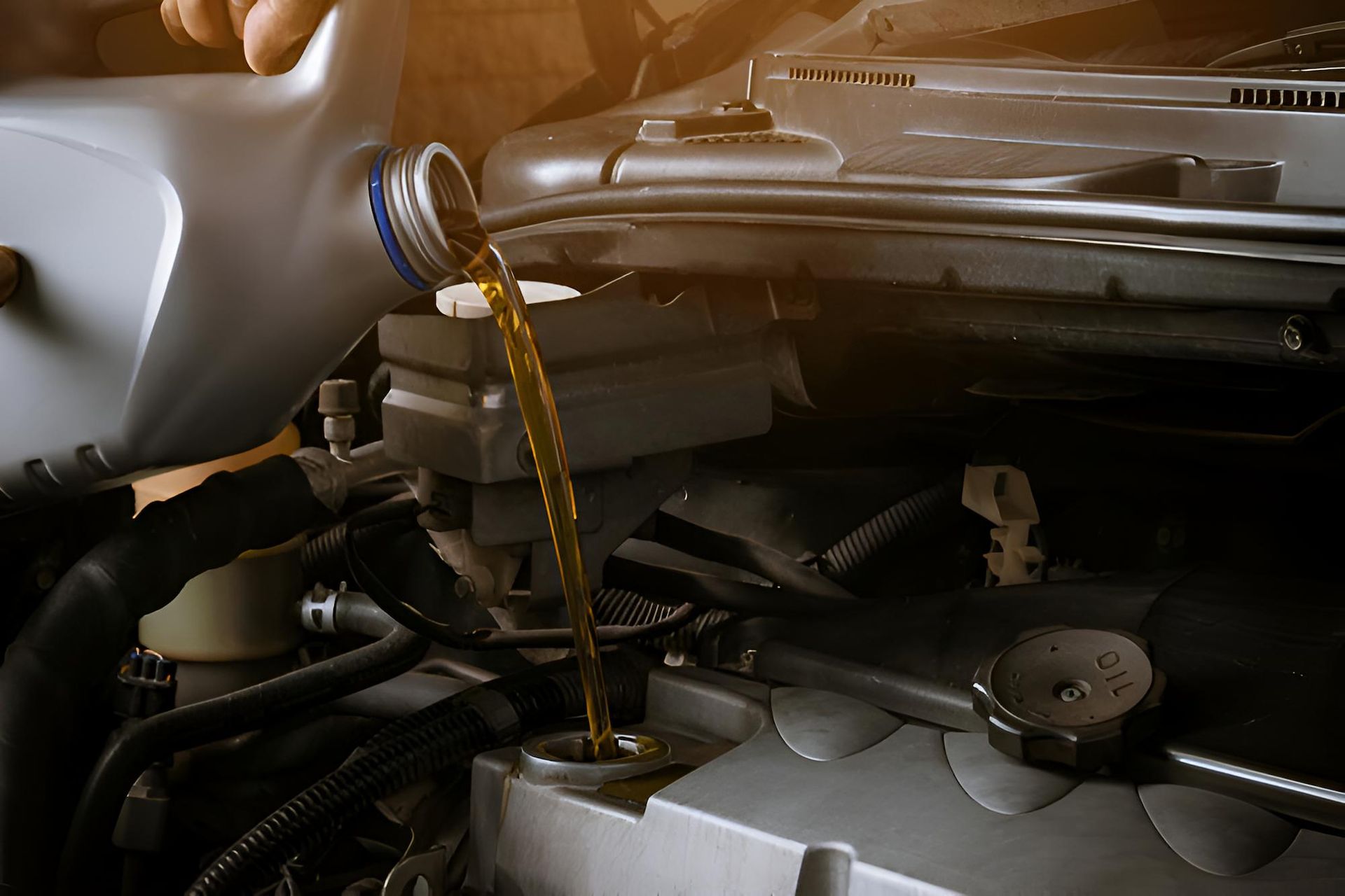 A Person is Pouring Oil Into a Car Engine — Mid Coast Bearing Centre in Gloucester, NSW