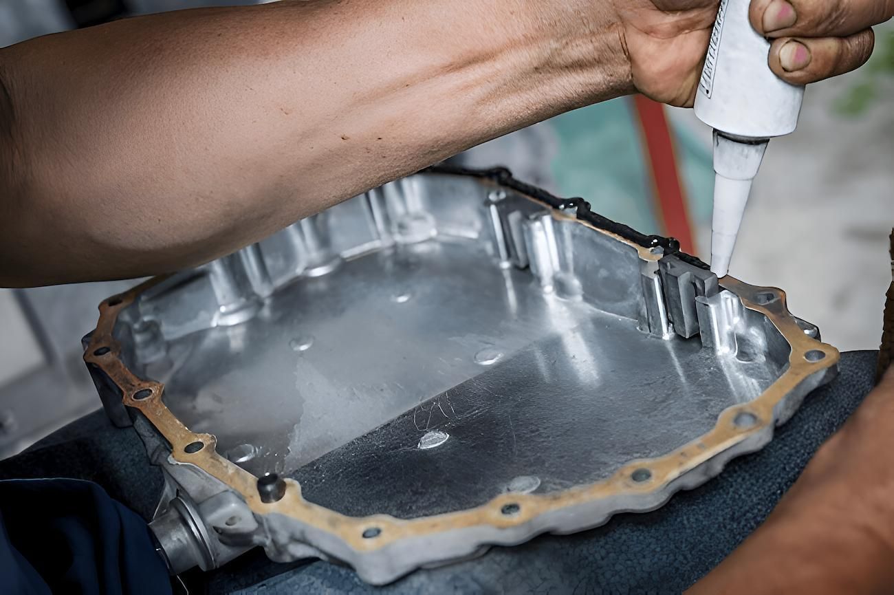 A Person is Applying Silicone to a Metal Object — Mid Coast Bearing Centre in Bulahdelah, NSW