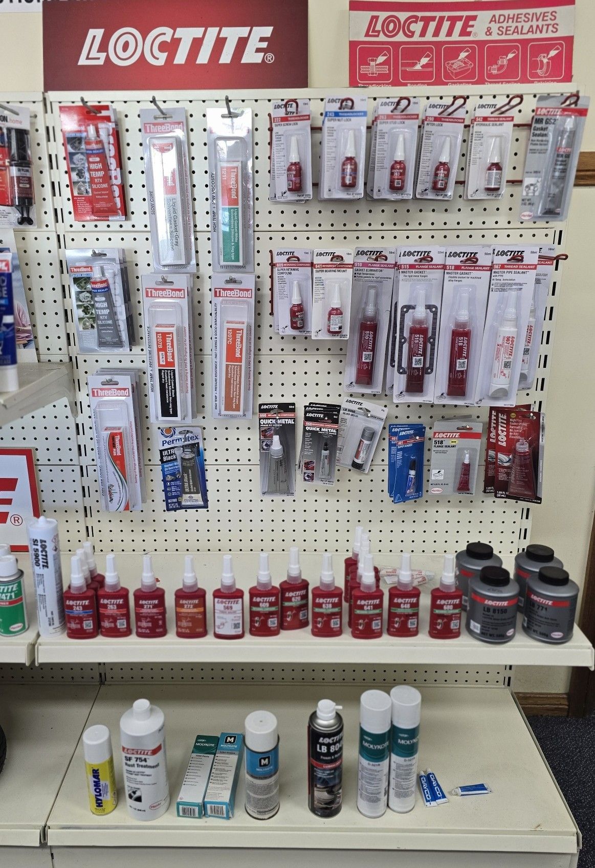 Loctite products on display in a hardware store. Various adhesives and sealants in red, white, and black packaging.— Mid Coast Bearing Centre in Bulahdelah, NSW