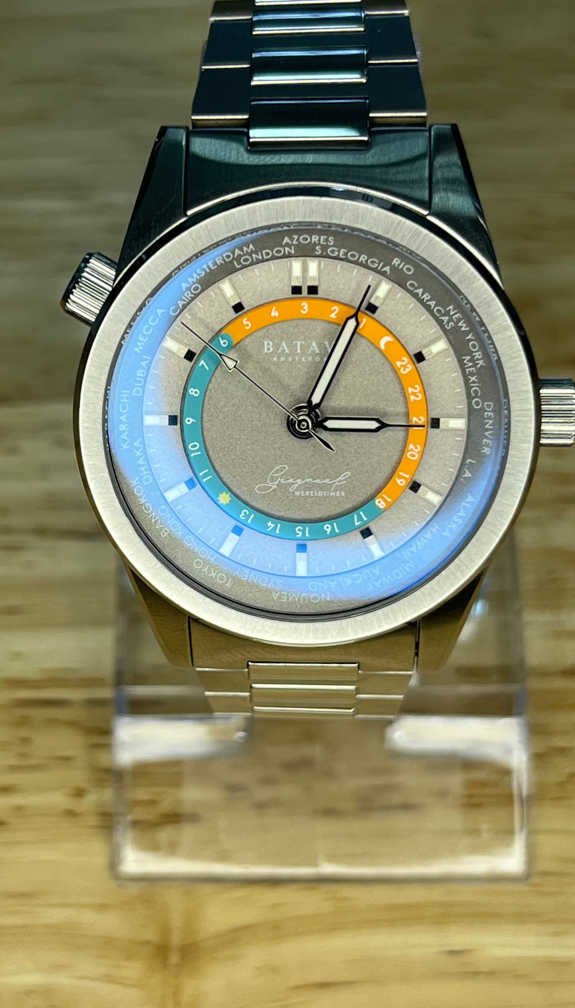 Silver watch with a gray face, blue and orange accents, and a silver band.