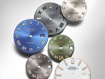 Various Rolex watch faces in different colors, including blue, green, silver, and white, with Roman numerals and markers.