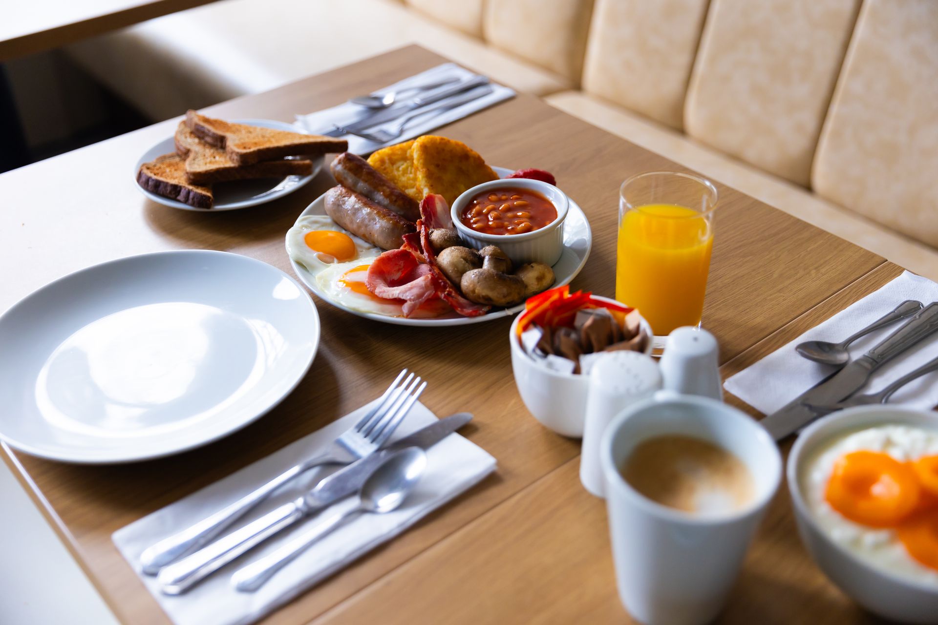 A table topped with plates of food and a cup of coffee.