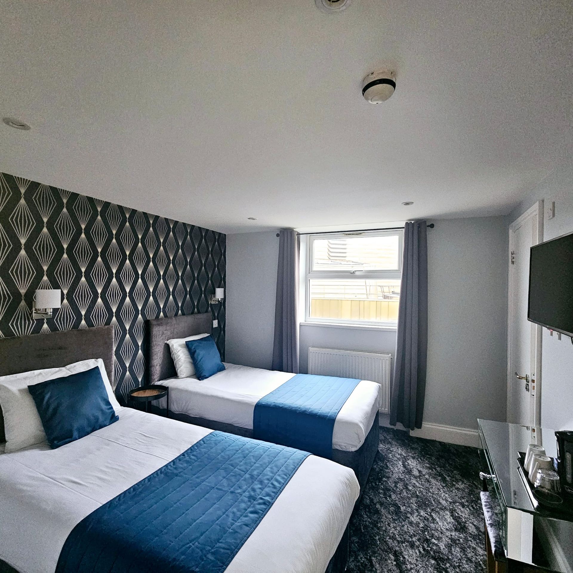 A hotel room with two beds and a television