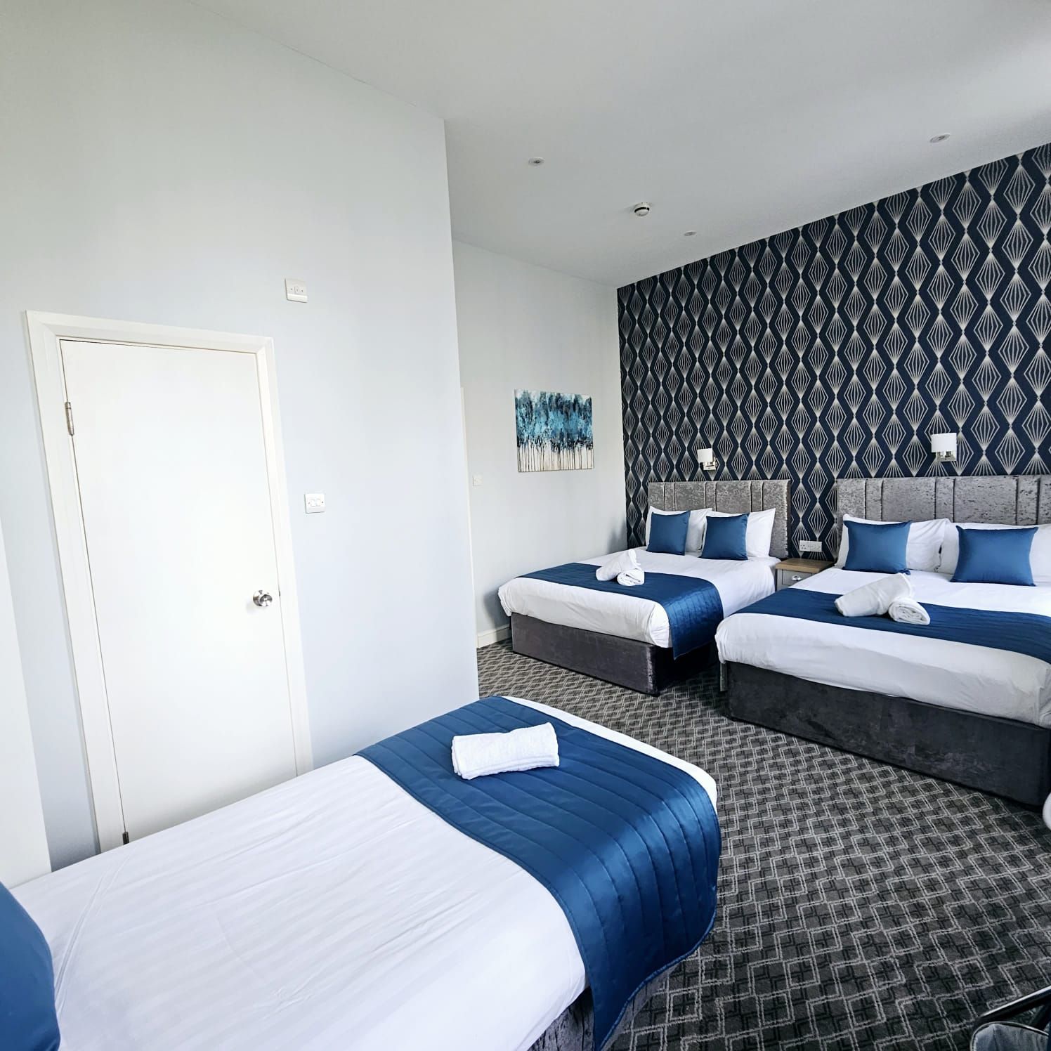 A hotel room with two beds and a door