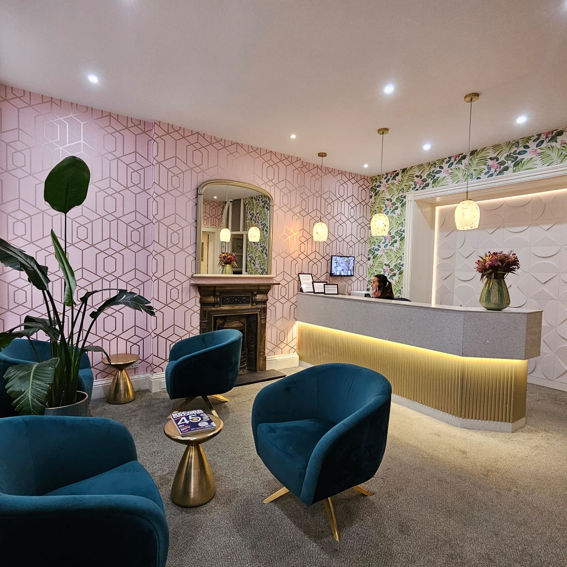 A waiting room with blue chairs and a reception desk