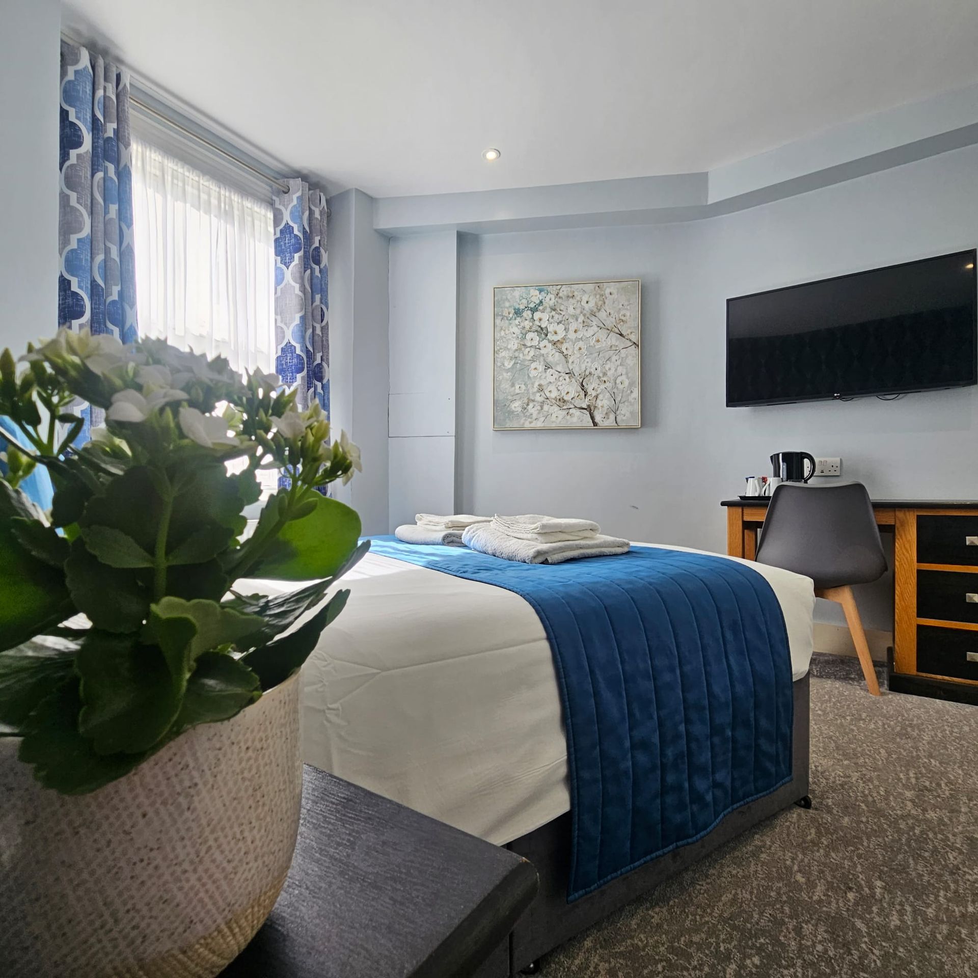 A hotel room with a large bed and a flat screen tv