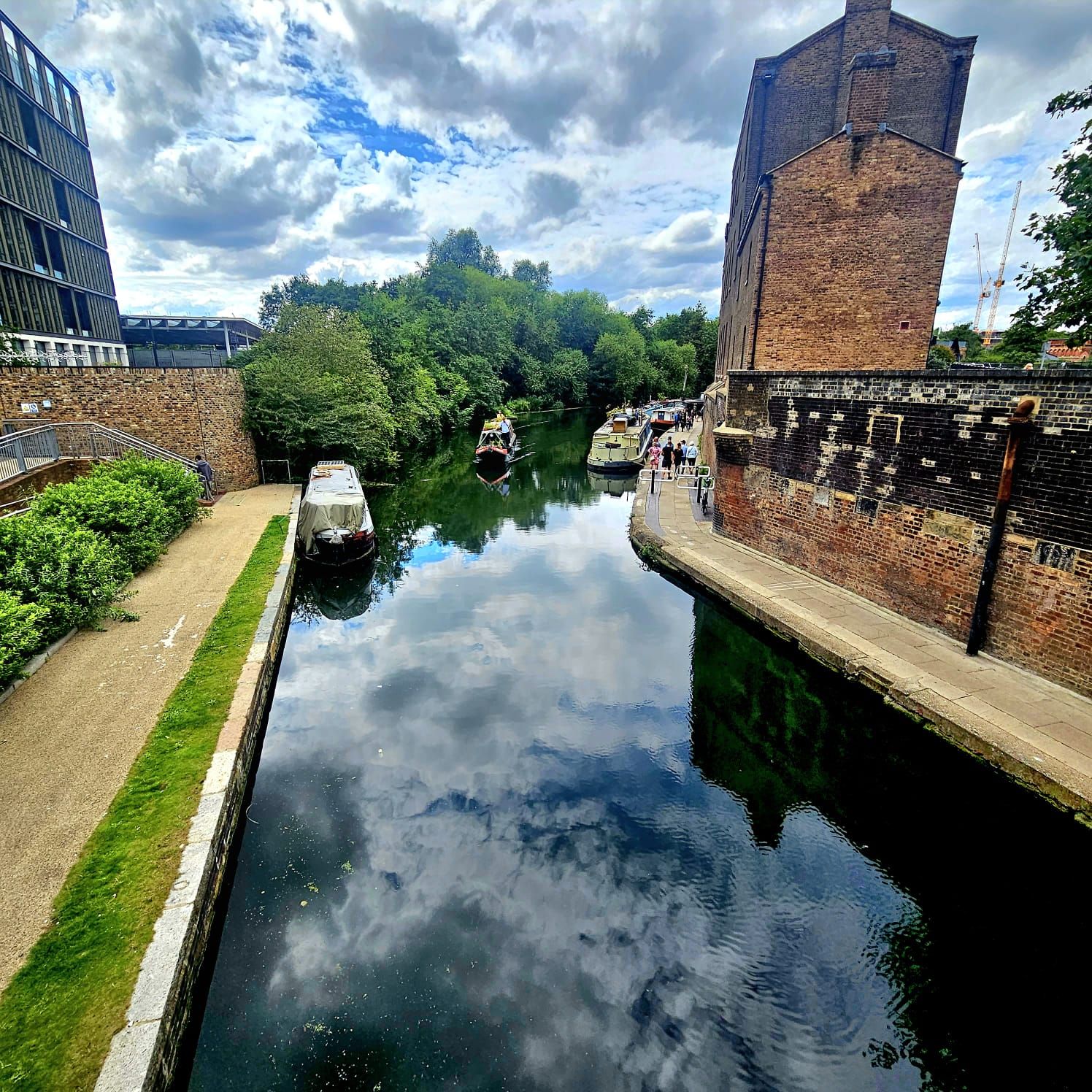 A river with boats on it and a brick building in the background