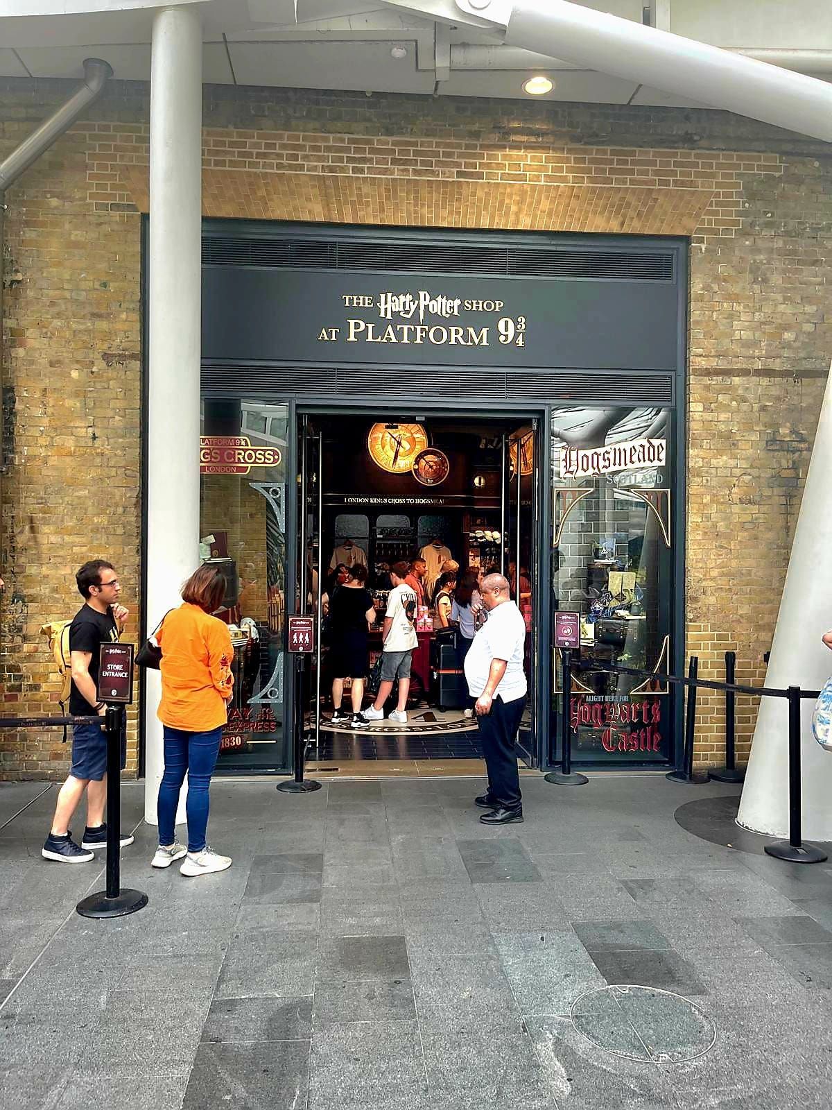 A group of people are standing outside of a store.