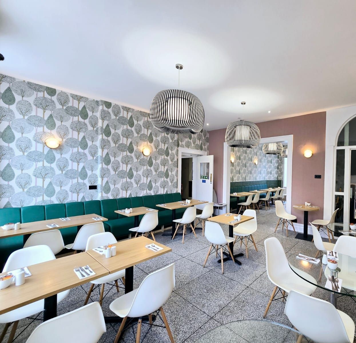 A restaurant with tables and chairs and a chandelier hanging from the ceiling.