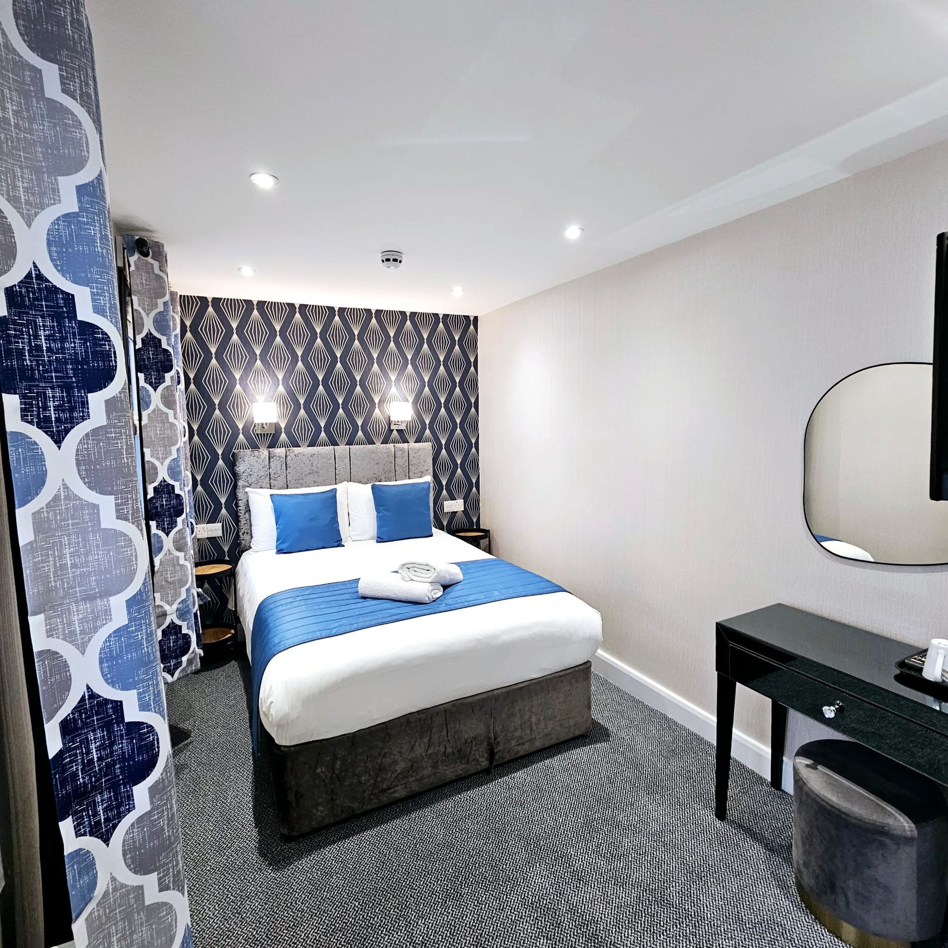 A hotel room with a large bed and a mirror