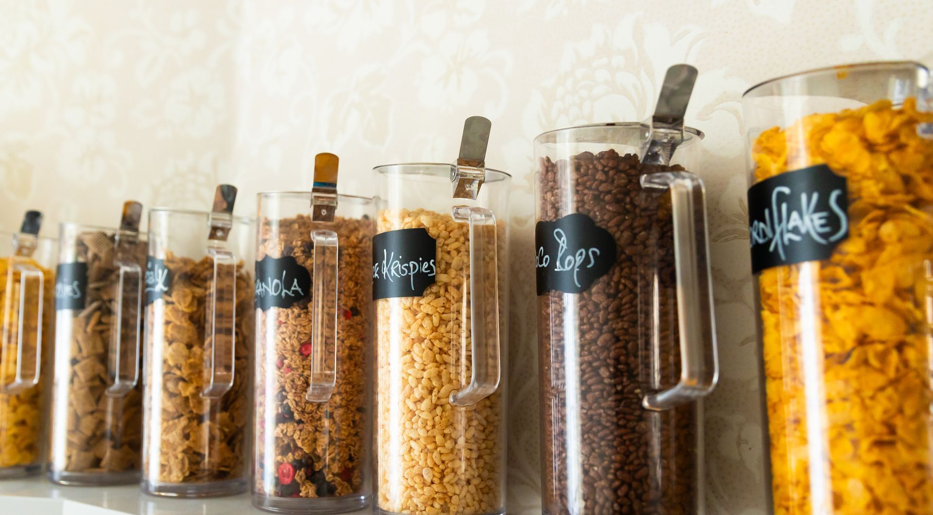A row of jars filled with different types of cereal.
