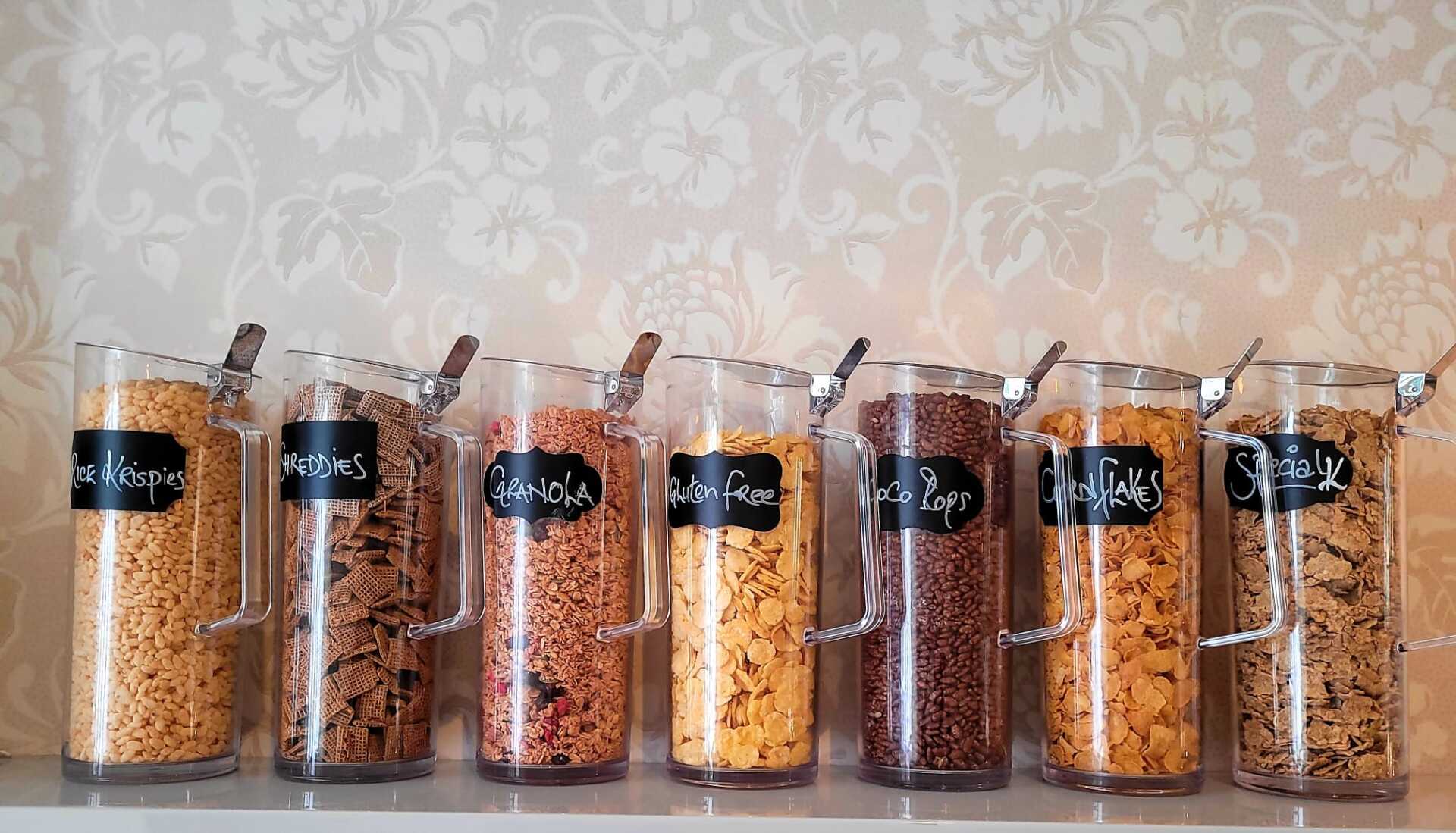 A row of glass jars filled with different types of cereal