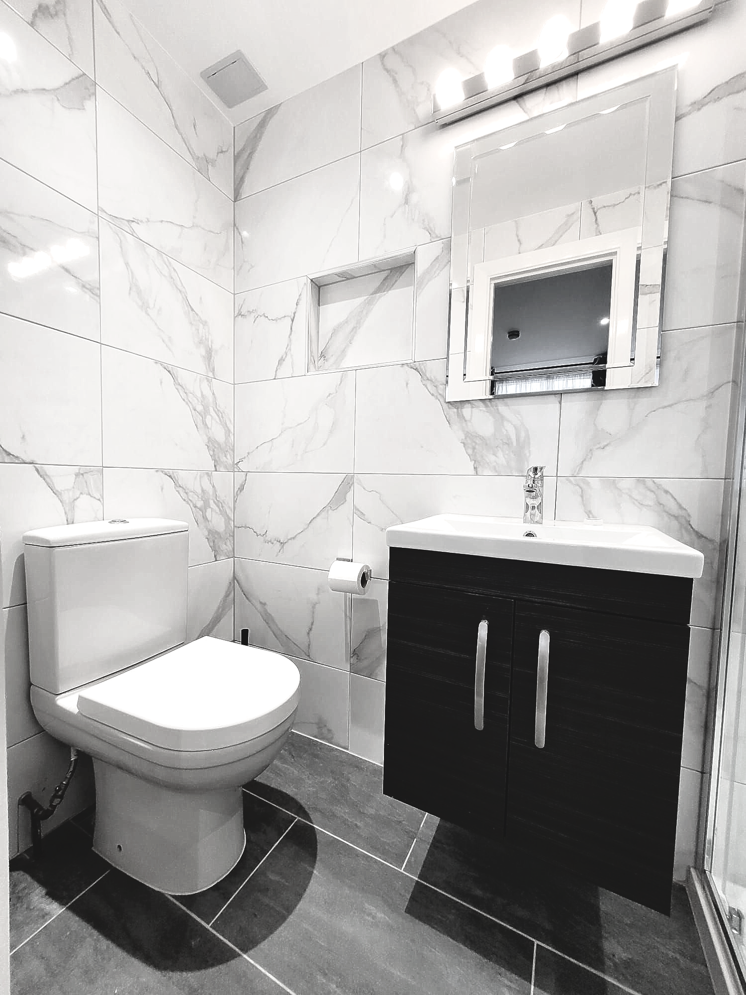 A bathroom with a toilet , sink and mirror