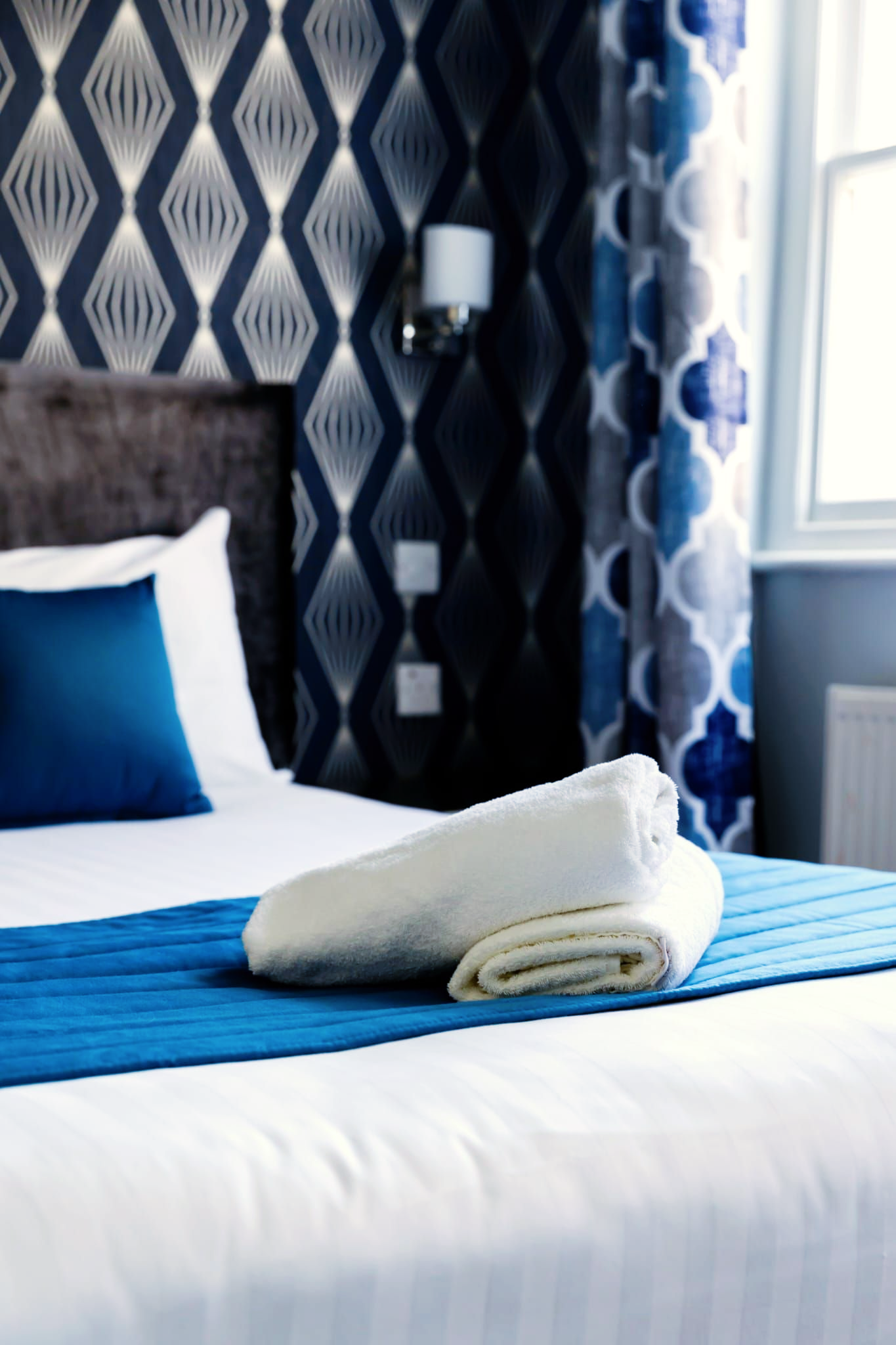 A hotel room with a bed and a towel on it