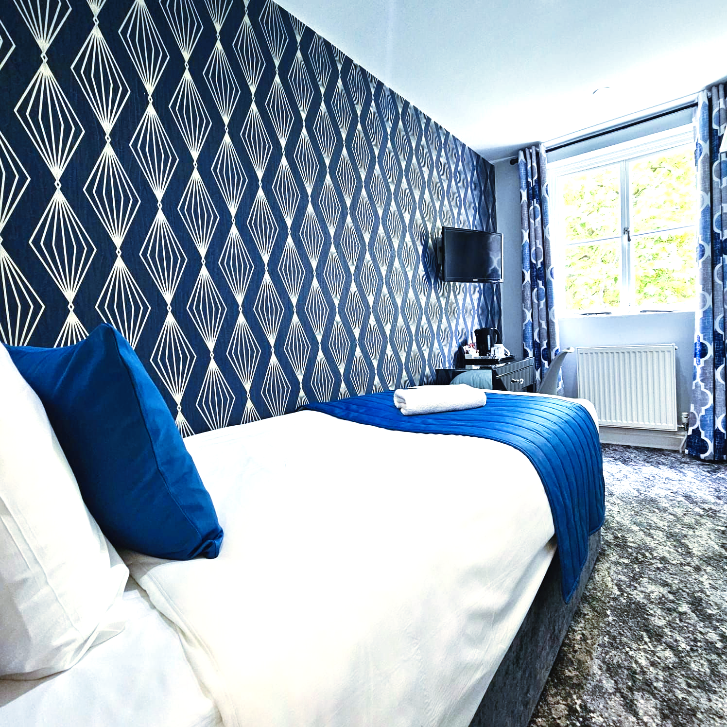 A hotel room with a bed and a window