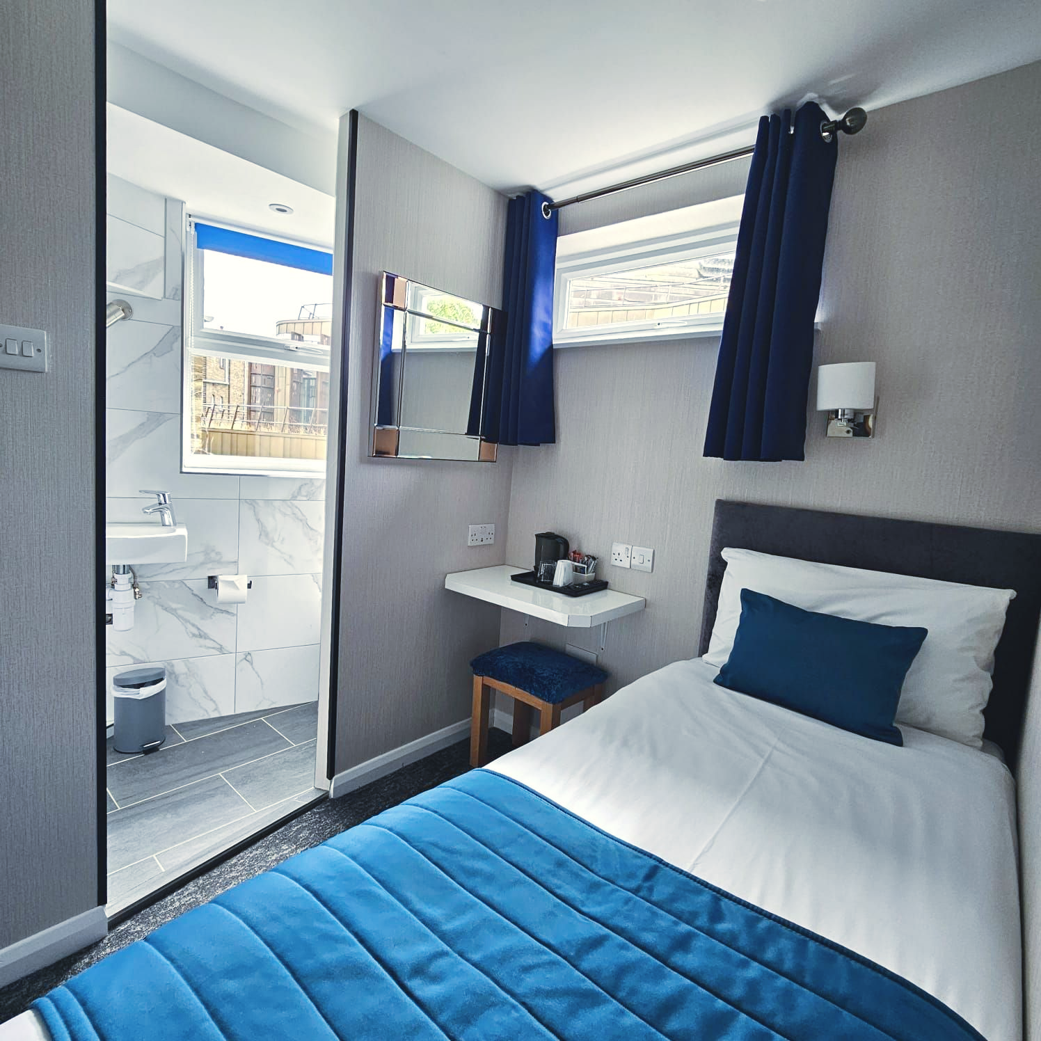 A hotel room with a bed and a mirror