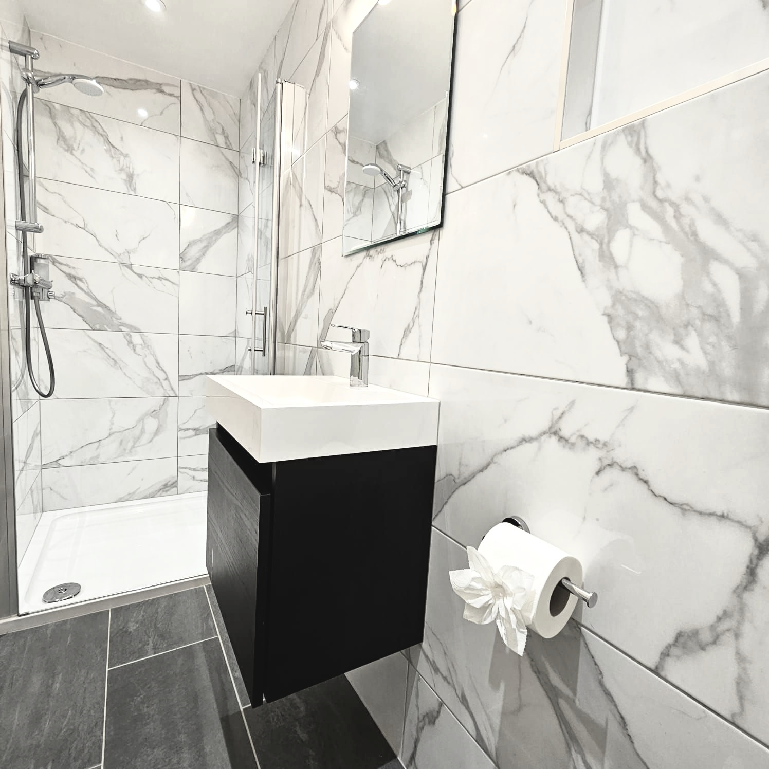 A bathroom with marble tiles and a sink