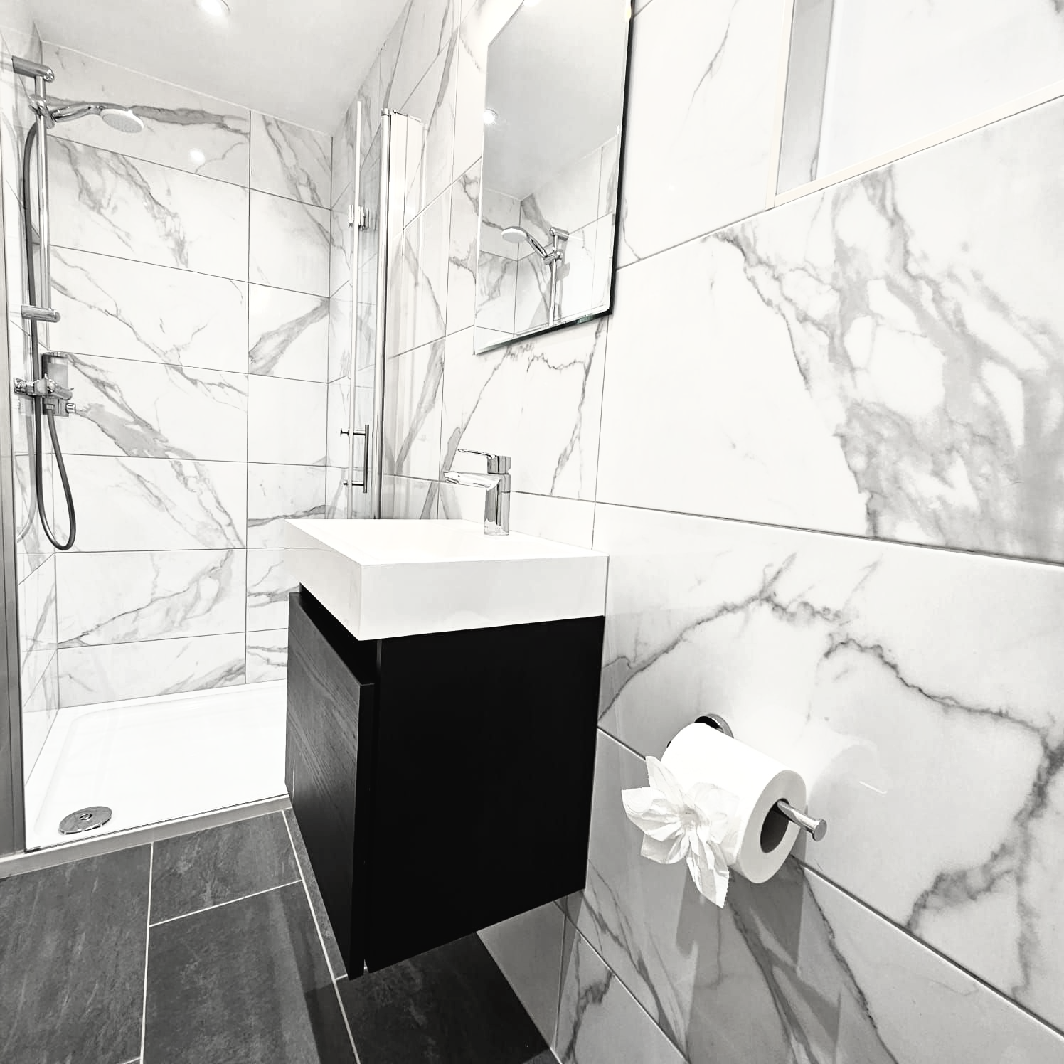 A bathroom with marble tiles and a sink