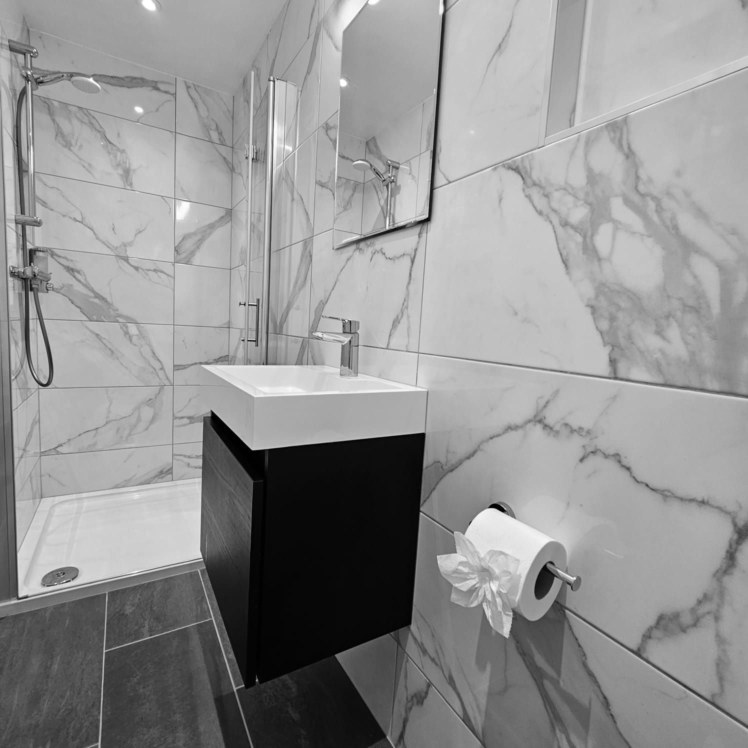 A bathroom with marble tiles and a sink