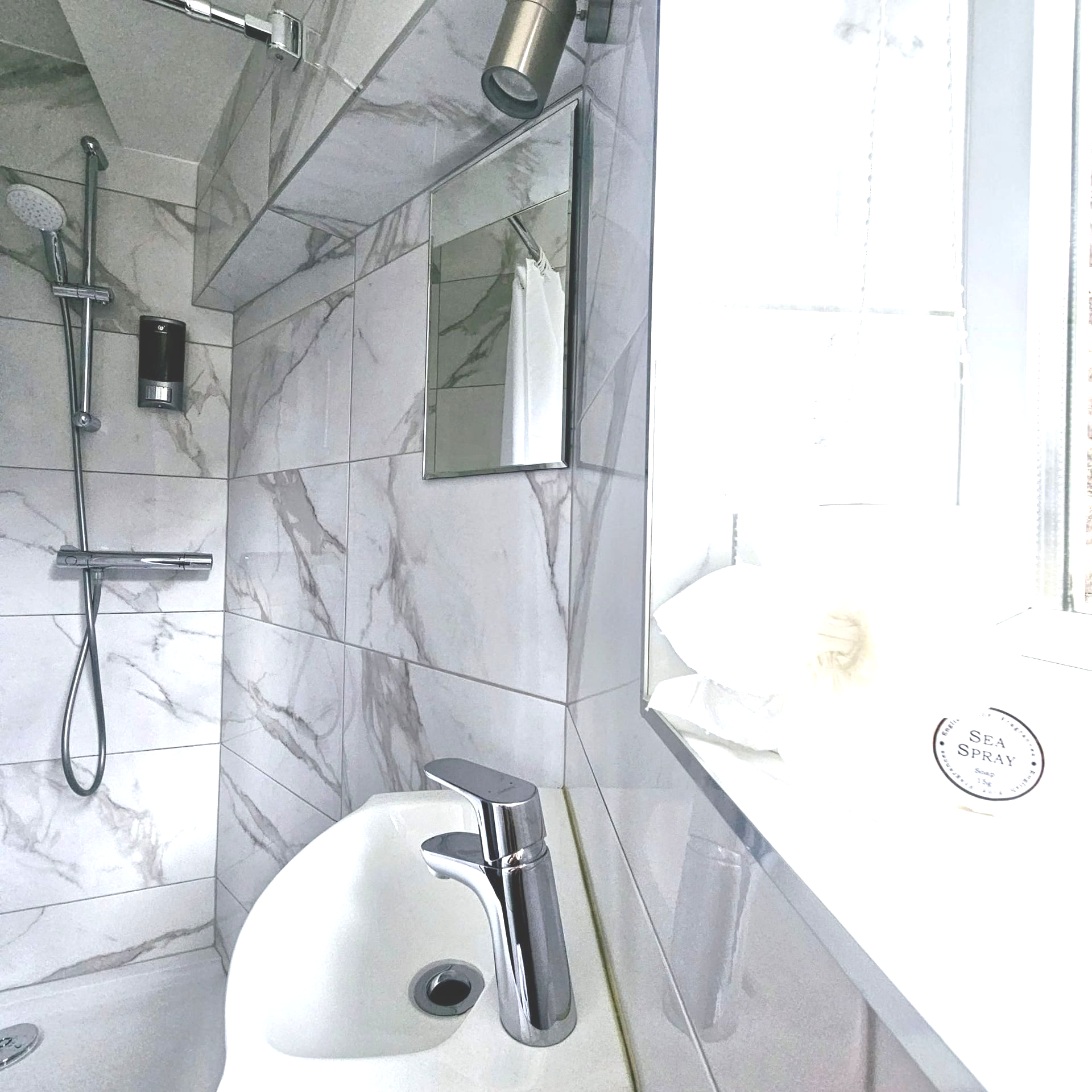 A bathroom with a sink a mirror and a window
