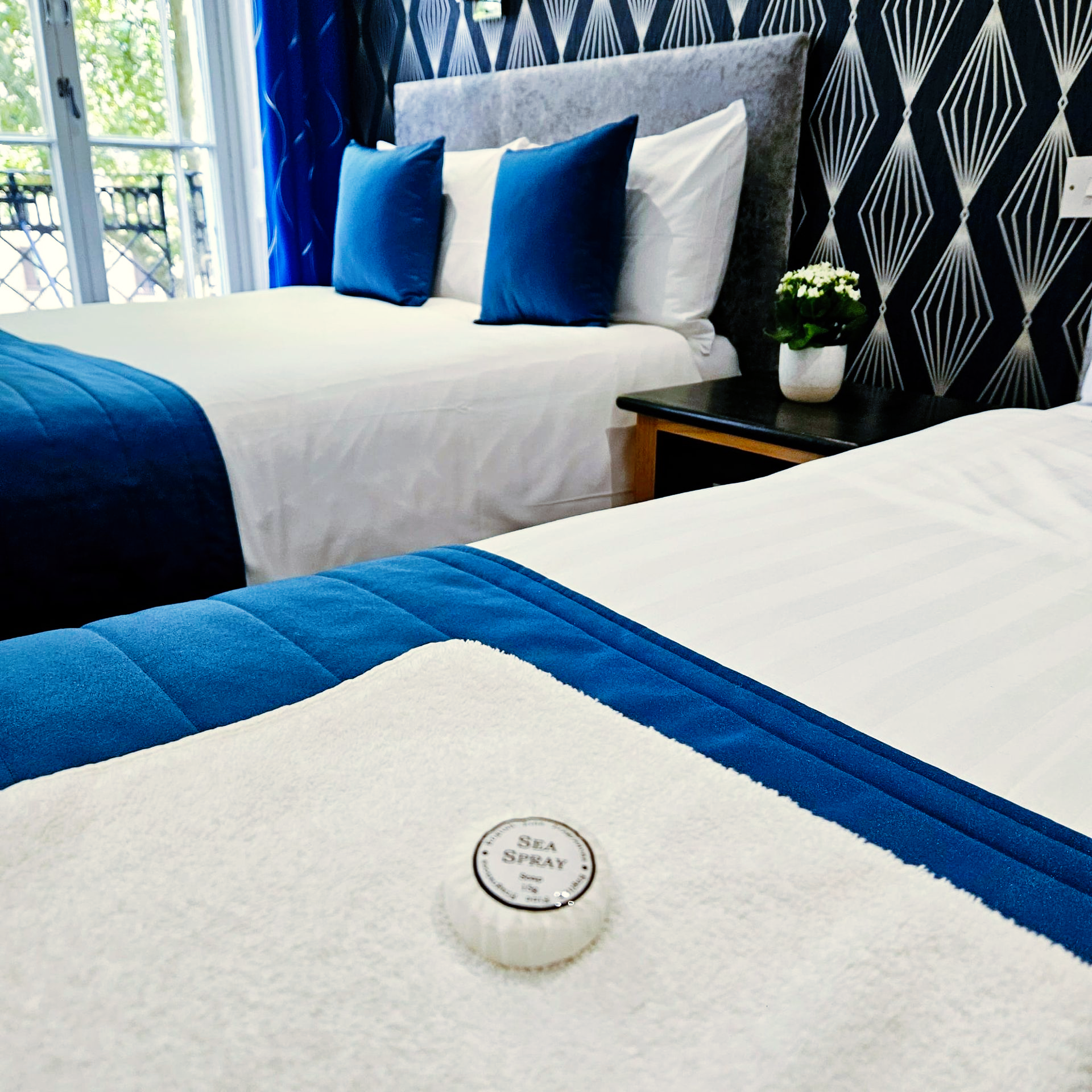 A hotel room with two beds and a soap on the bed