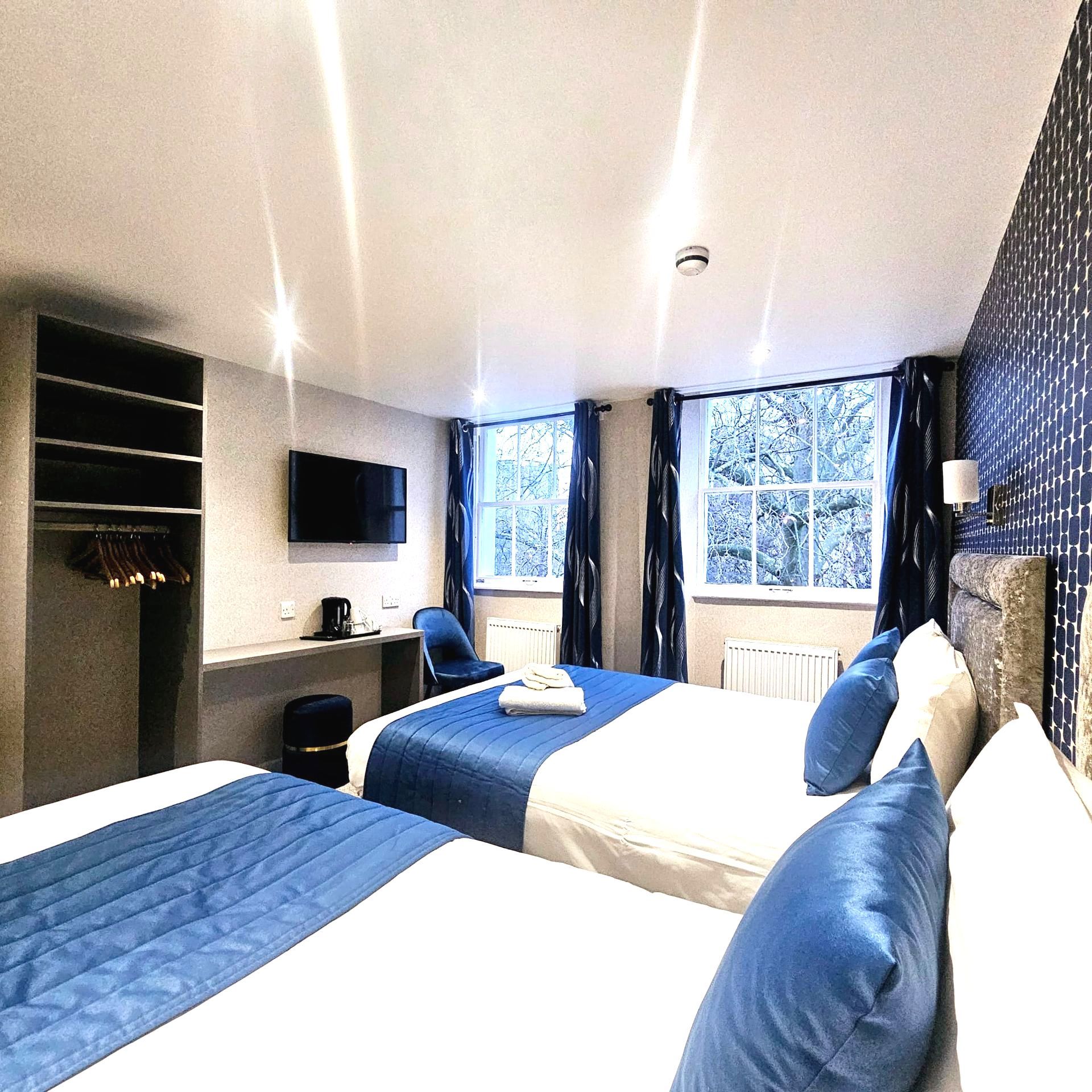 A hotel room with two beds and a television