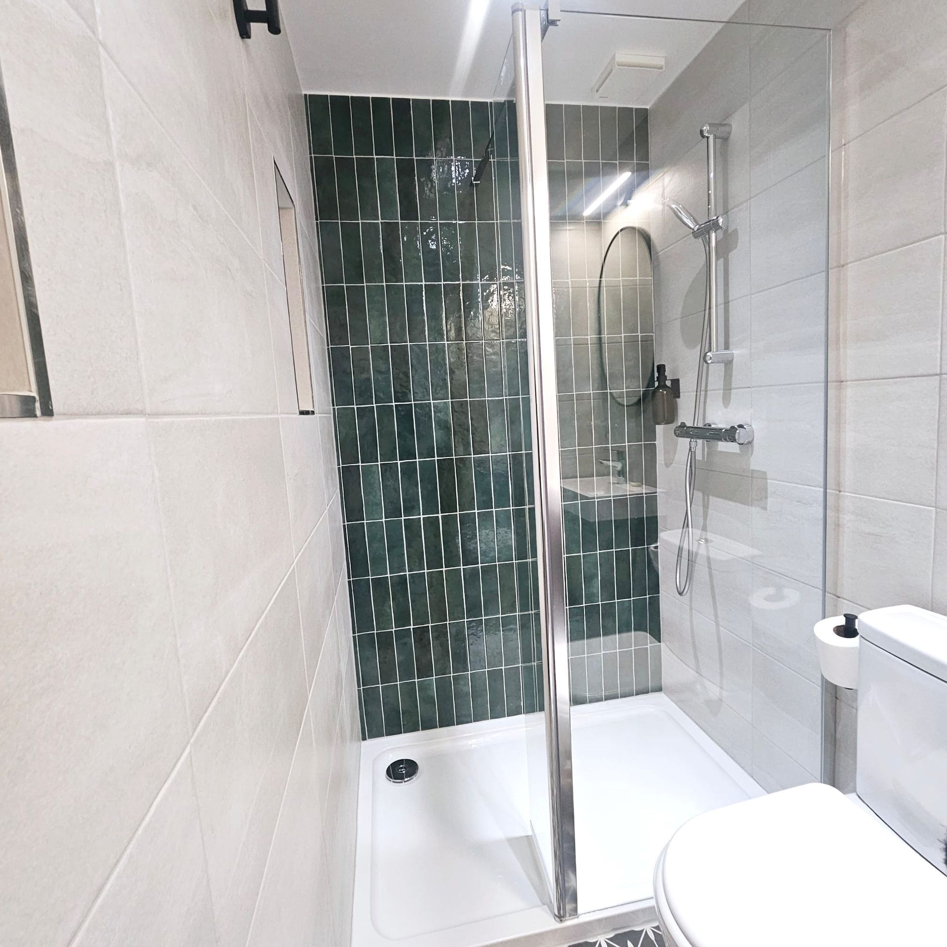A bathroom with a toilet a shower and a mirror