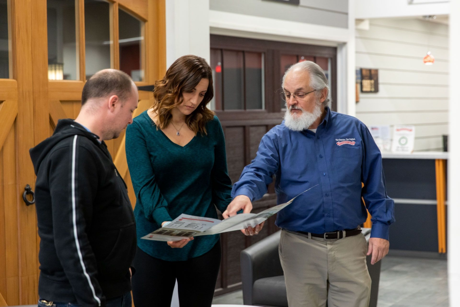 Three people reviewing a map together in a bright indoor lobby