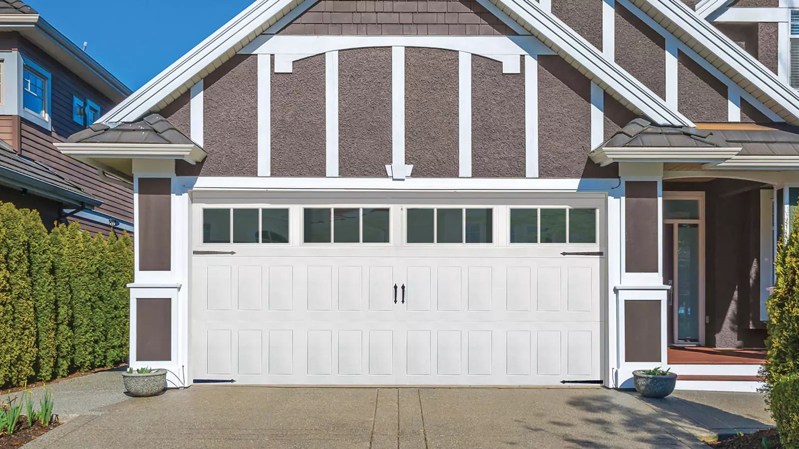 Suburban house exterior with a white garage door and brick-and-siding facade