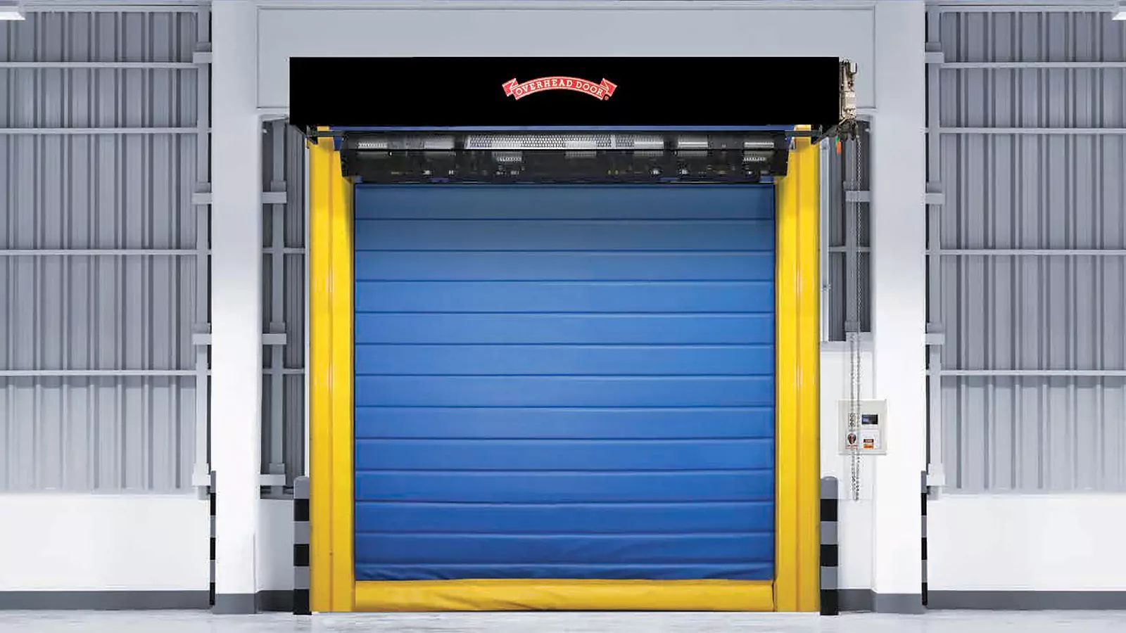 Blue industrial garage door centered in a metal warehouse bay with yellow trim