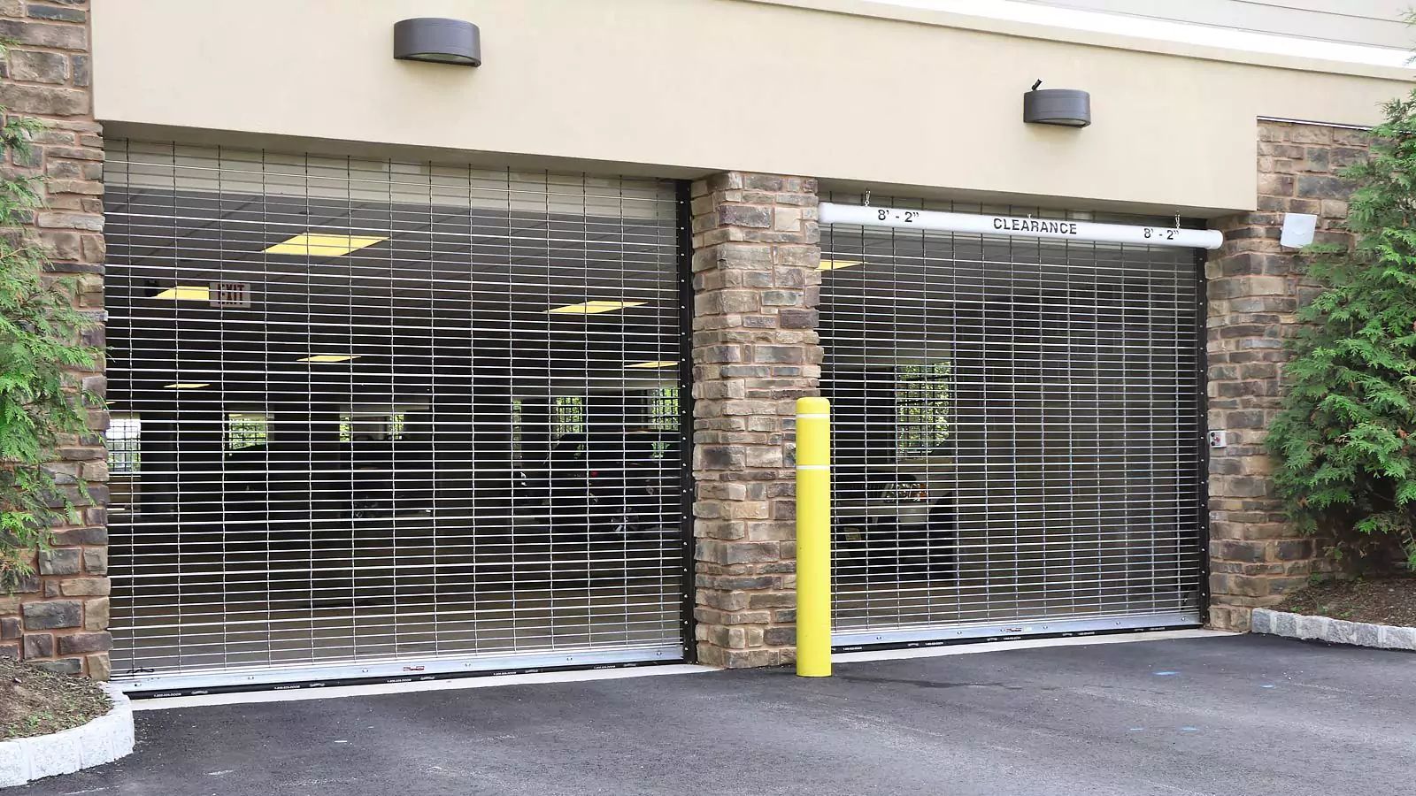 Closed storefront parking garage with metal roll-down gates and stone columns