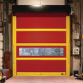 Red industrial roll-up door with yellow stripes and a narrow window in a garage workshop
