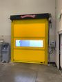 Yellow industrial garage door with a small window in a warehouse setting