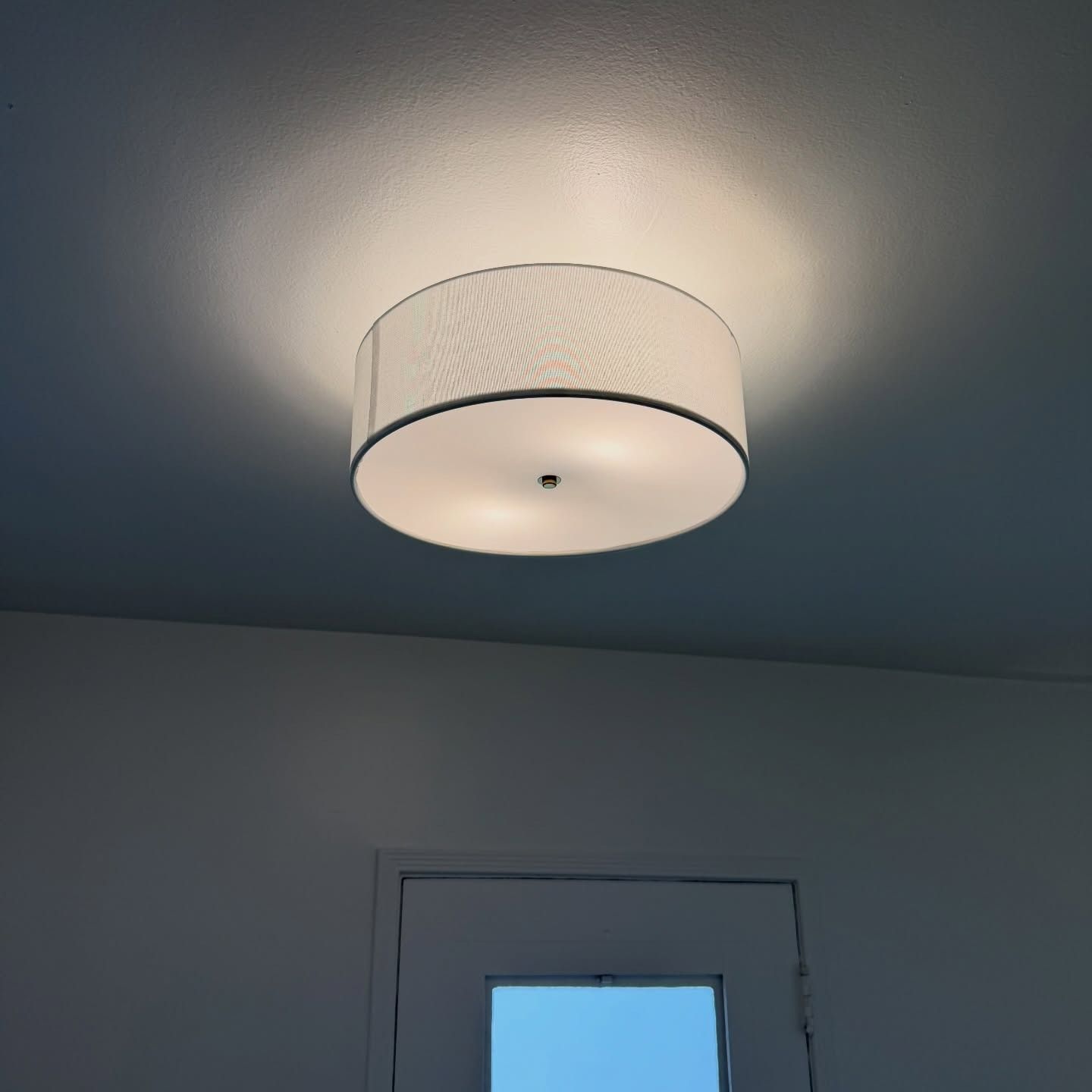 Ceiling light fixture on a blue-gray ceiling above a door frame