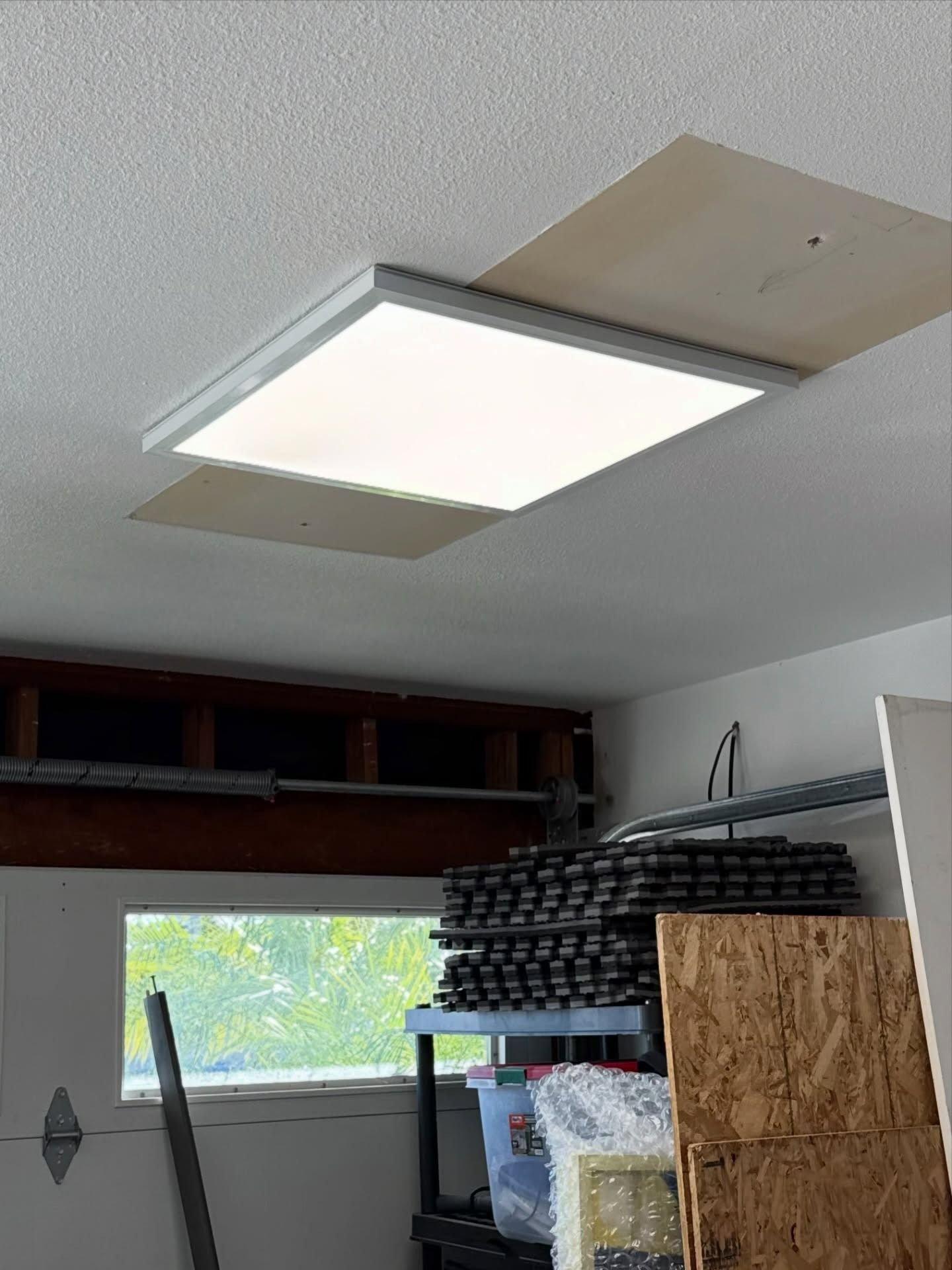 Indoor room with ceiling panel light and a garage shelf below a small window