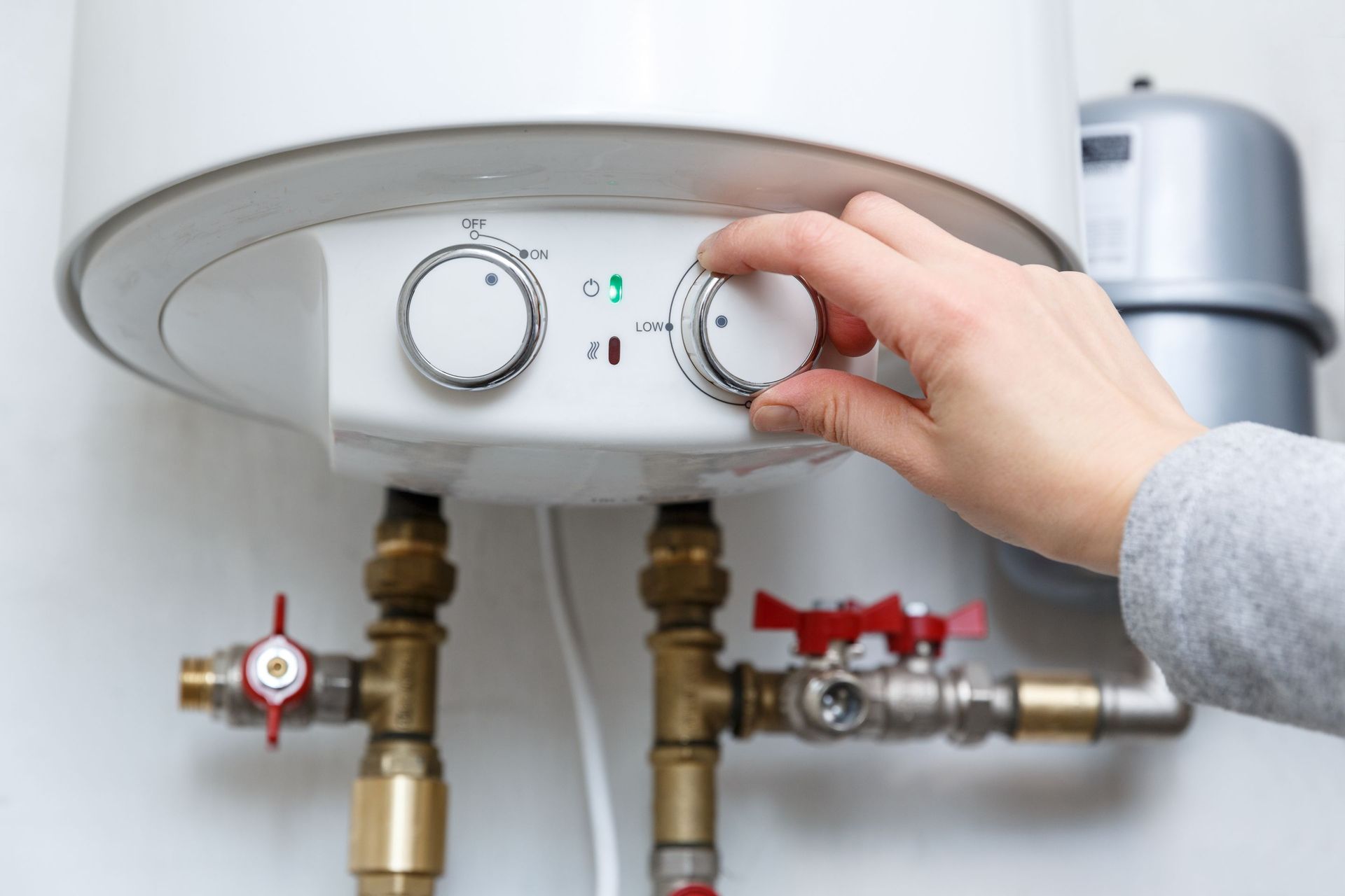 female hand puts thermostat electric water