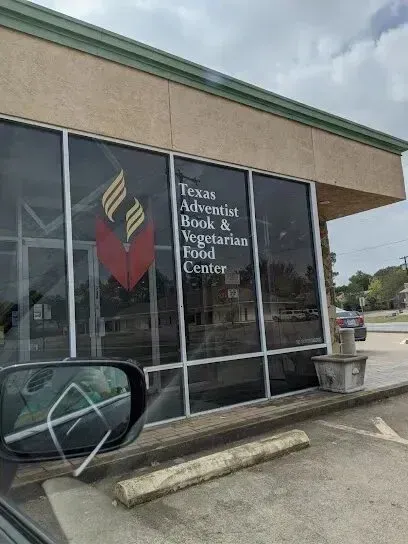 Burleson Electrician
- Exterior of a store with large windows displaying “Texas Adventist Book & Vegetarian Food Center.” A cloudy sky reflects on the glass, conveying a calm atmosphere.