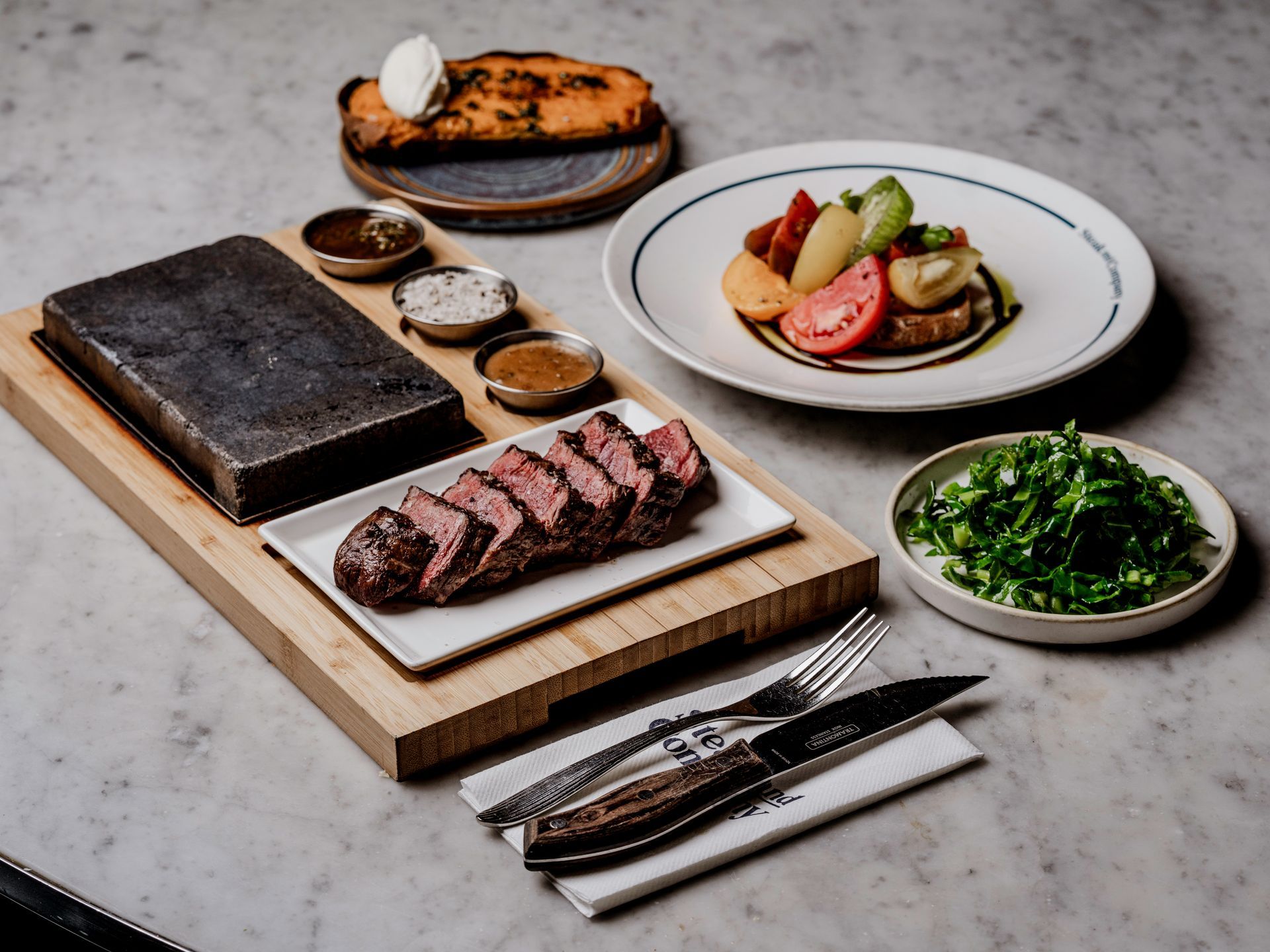 Halal sliced steak with a Hot Stone, peppercorn sauce, butter and salt, with a green salad, baked Sweet Potato and Heritage Tomatos.