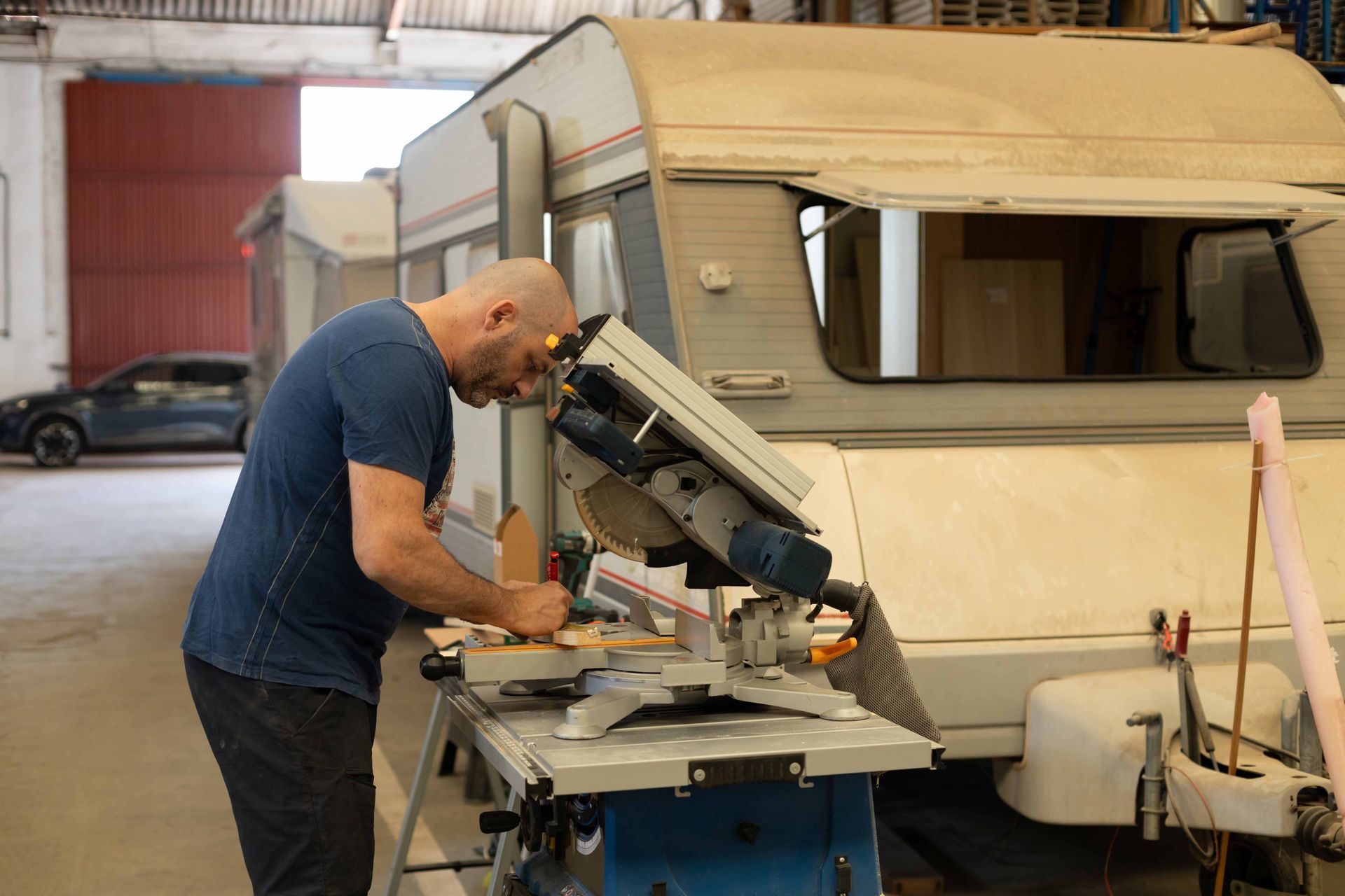 A tradesperson is renovating a caravan using a wood saw machine. A tradesperson is renovating a caravan using a wood saw machine.