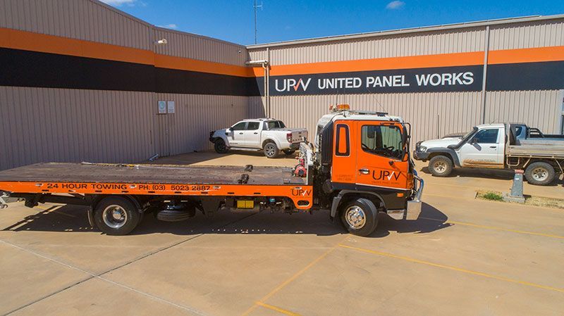 Towing Services — Mildura, VIC — United Panel Works Orange flatbed tow truck parked outside