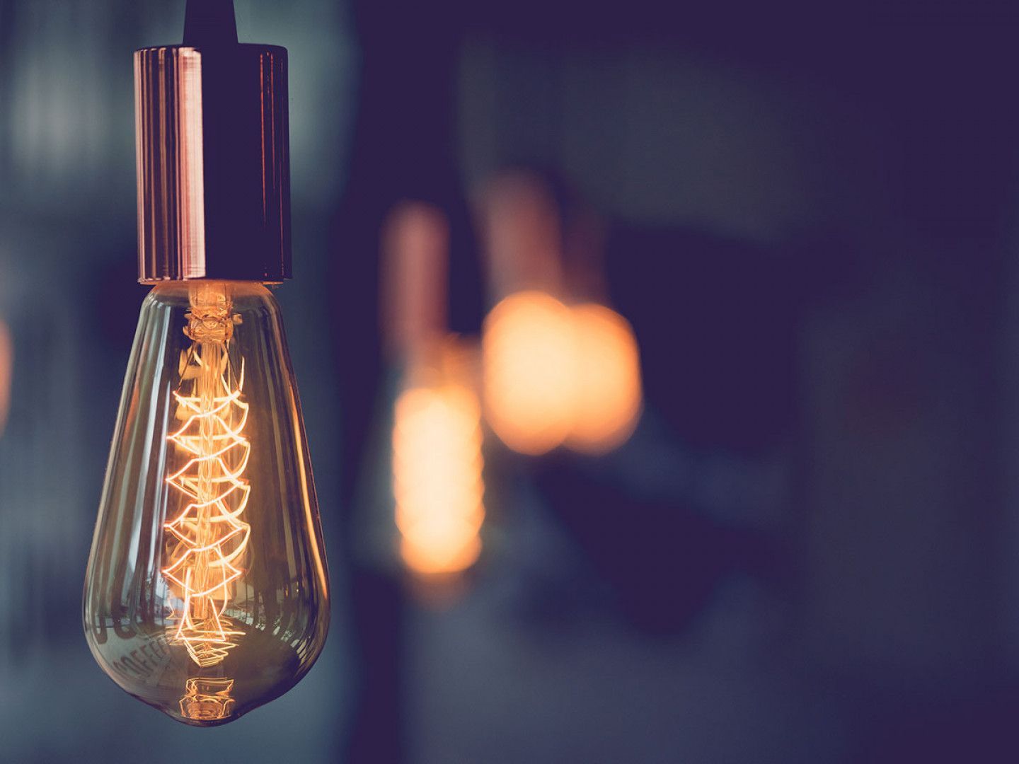 A close up of a light bulb hanging from a ceiling.