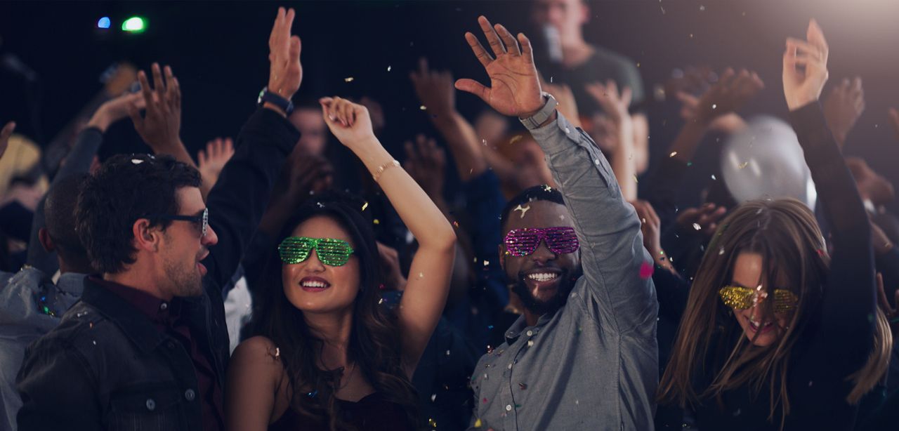 A group of people are dancing at a party in a club.